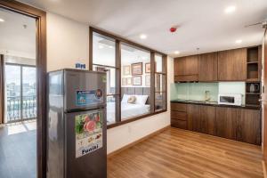 a kitchen with a stainless steel refrigerator and a bedroom at Langmandi Hotel & Apartment in Da Nang