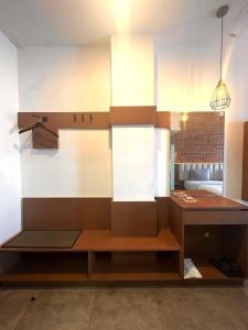 a kitchen with white cabinets and a bench in it at Xtra Hotel Bengkulu in Bengkulu