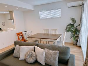una sala de estar con un sofá y una mesa en Araha Beachway Inn, en Chatan