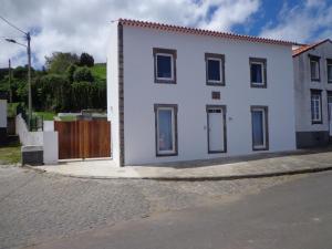 a white house on the side of a street at Casa do Simão in Nordeste