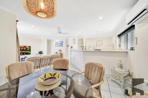 een eetkamer met een glazen tafel en stoelen bij 1-20 Bauer Street in Bargara +7 foto's