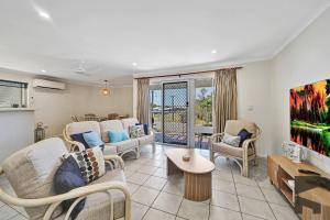 een woonkamer met banken en een tv bij 1-20 Bauer Street in Bargara