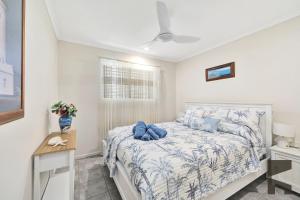 een slaapkamer met een bed met blauwe kussens bij 1-20 Bauer Street in Bargara