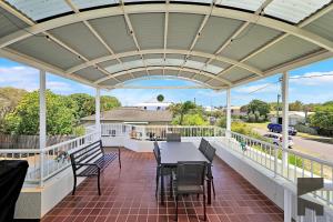 een terras met een tafel en stoelen op een balkon bij 1-20 Bauer Street in Bargara