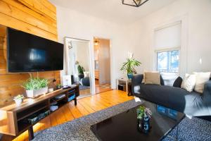 Una sala de estar con un sofá y un televisor de pantalla plana. en Cambridge Base Steps to Porter Square, en Old Cambridge