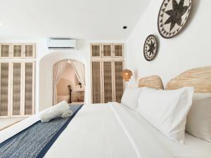 a white bedroom with a large bed and a clock on the wall at Villa Aurora - Stylish 2 Bedroom Villa with Mediterranean Style in Badung +37 photos