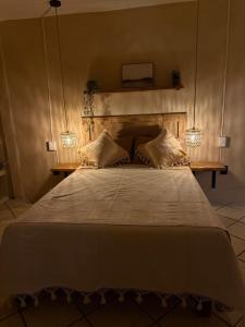 オアハカにあるCasa Resplandorのベッドルーム1室(大型ベッド1台、ランプ2つ付)