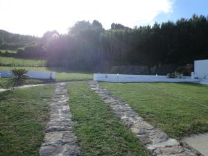 a garden with a stone walkway next to a lake at Casa do Simão in Nordeste