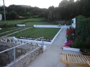 a garden with a bench and a stone wall at Casa do Simão in Nordeste