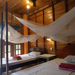 a bedroom with two beds and a mosquito net at FamilyHouse & Trekking in Banlung