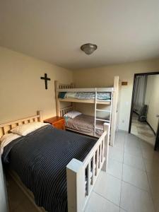 a bedroom with two bunk beds and a cross on the wall at Sunsets & Surf Beach House near Puerto Nuevo in Raulis +22 photos