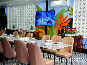 a dining room with a table and chairs and a painting at Kangaroo homestay in Cat Ba