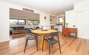 a kitchen and living room with a table and chairs at Lighthouse-hideaway in Cape Foulwind