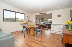 a kitchen and living room with a table and chairs at Lighthouse-hideaway in Cape Foulwind +19 photos