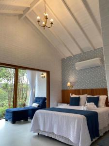 a bedroom with two beds and a window at Colina dos Colibris in Santa Teresa