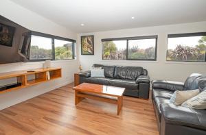 a living room with a couch and a coffee table at Lighthouse-hideaway in Cape Foulwind
