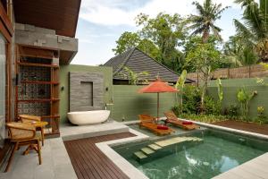 a backyard with a swimming pool and a bath tub at Nauma Ubud Villa in Ubud