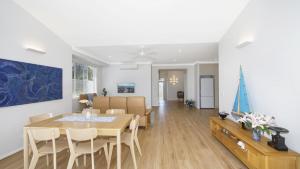 a dining room and living room with a table and chairs at Summer Splendor - Ettalong Beach in Ettalong Beach