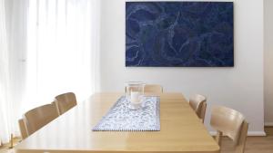 a dining room table with a candle on a napkin at Summer Splendor - Ettalong Beach in Ettalong Beach