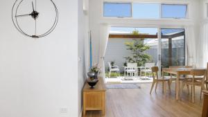 a kitchen and dining room with a large clock on the wall at Summer Splendor - Ettalong Beach in Ettalong Beach