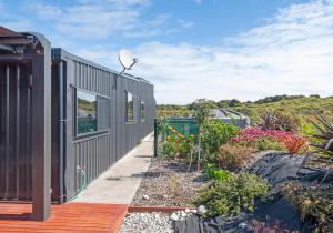 a tiny house with a garden on a deck at Lighthouse-hideaway in Cape Foulwind