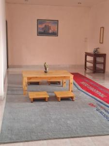 a living room with a wooden table and benches at Padang Besar Border Private room & Hostel in Sathani Padang Besa