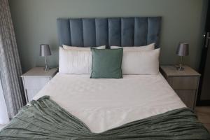 a bedroom with a large bed with a blue headboard at GuestHouseVine&Stone in Clarens