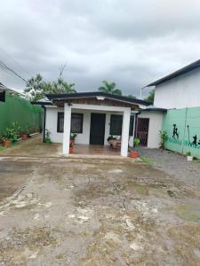 a white house with a green fence at Apartamentos GoZu # 1 in Puerto Viejo