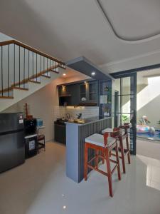 eine Küche mit Treppe, Tisch und Stühlen in der Unterkunft QueeNdra Villa in Tlekung