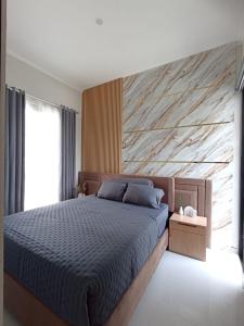 ein Schlafzimmer mit einem Bett und einer Holzwand in der Unterkunft QueeNdra Villa in Tlekung + 9 Fotos