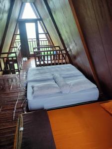 a bed in the middle of a room at The Aisyah Cabin in Wonosobo