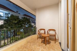 a balcony with two chairs and a table at The Hita Apartement in Seminyak