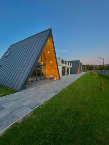 a building with a black roof on top of a field at A Frame Bâlea Chalet in Cîrţişoara
