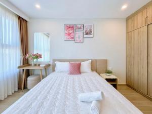 une chambre avec un grand lit blanc avec des oreillers roses dans l'établissement The Sóng Tourist Apartment Tam Thắng Vũng Tàu, à Vung Tau 166 autres photos