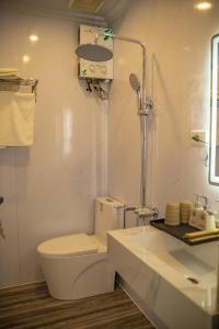a white bathroom with a toilet and a sink at Háng Đồng Ecolodge in Bắc Yên