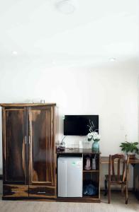 ein Wohnzimmer mit einem Schrank und einem Fernseher in der Unterkunft Thủy Tiên-Thạch Thảo in Da Lat