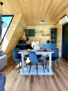 a dining room with a table and blue chairs at A Frame Bâlea Chalet in Cîrţişoara
