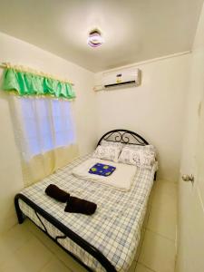 een kleine slaapkamer met een bed en een raam bij Balai Camu Fully Furnished Luxury Home in Sampong