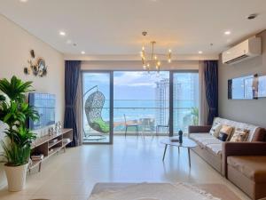 un salon avec un canapé et une grande fenêtre dans l'établissement The Sóng Tourist Apartment Tam Thắng Vũng Tàu, à Vung Tau