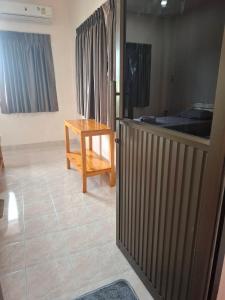 a room with a wooden table and a bed at Padang Besar Border Private room & Hostel in Sathani Padang Besa