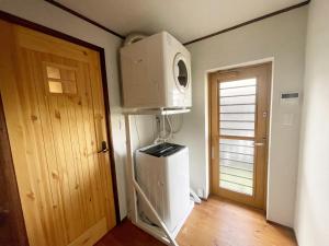 a room with a microwave and a refrigerator and a door at 安曇野ふくろうハウス The OWL Villa mountain view in Hotaka +37 photos