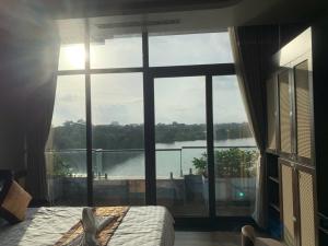Dormitorio con ventana grande con vistas al agua en MD Hotel, en Mỹ Lộc 15 fotos más