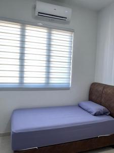 a bed sitting in a room with a window at UmiAbah Residensi Adelia4 in Kajang
