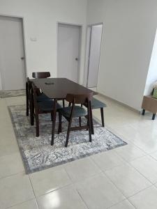 a wooden table and chairs on a rug in a room at UmiAbah Residensi Adelia4 in Kajang