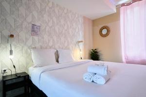 a bedroom with a white bed with towels on it at NG Prestige - Lille I Roubaix Centre I Grande Rue - Studio - Netflix & Wifi in Roubaix