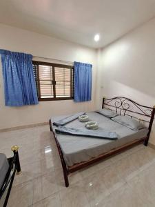 a bedroom with a large bed with blue curtains at Padang Besar Border Private room & Hostel in Sathani Padang Besa +19 photos