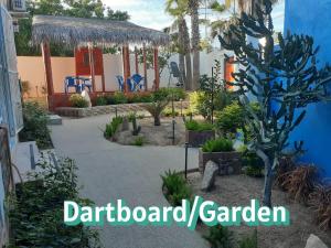 a garden in front of a blue building with a tree at Posada Nomad in San José del Cabo