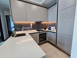 Una cocina con gabinetes blancos y encimera. en Opus Residences by Star Haven, en Kuala Lumpur