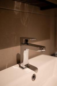 a silver sink faucet on top of a white sink at Paxtonz Suites,1Utama,IKEA Damansara,SEGi,Desa Park in Petaling Jaya