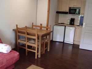 une petite cuisine avec une table et deux appareils blancs dans l'établissement Appartement 4 pers. avec balcon au calme, accès piscine - FR-1-814-167, à Vassivière